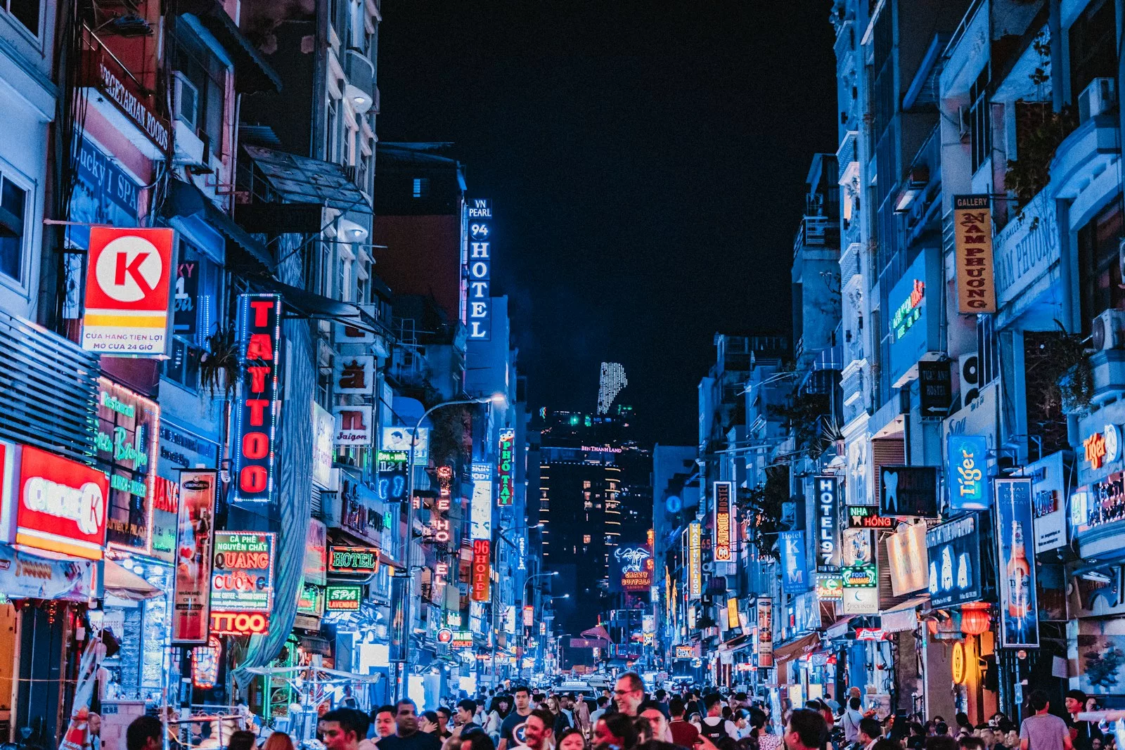 people between city buildings at night